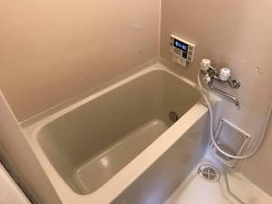 a bath tub with a hose in a bathroom at PhaseSpace in Sekimachi