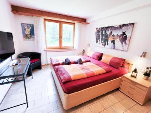 a bedroom with a large red bed and a television at Apartment Curtins18 by Interhome in Pontresina
