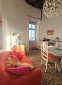 een woonkamer met een oranje bank en een tafel bij Tour-Moulin in Épire