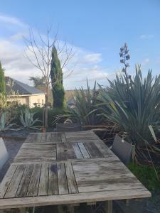 een houten tafel in een tuin met planten bij Tour-Moulin in Épire