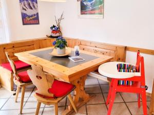a wooden table with chairs and a small table and a table at Apartment Curtins18 by Interhome in Pontresina