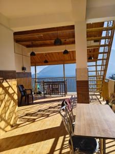 a porch with a wooden table and chairs on a deck at Rana Ridges in Banjār +4 photos