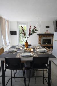 einen Tisch mit Tellern und Gläsern und eine Vase mit Blumen in der Unterkunft Appartement Terrasse à Mennetou sur Cher "La Cité Médiéval in Mennetou-sur-Cher