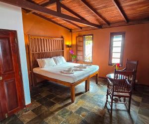 een slaapkamer met een bed en 2 stoelen. bij Villa Kusum in Hikkaduwa +77 foto's