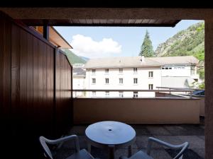 ein Balkon mit Tisch und Stühlen und ein Gebäude in der Unterkunft Studio 4 Pers avec Balcon, WiFi et Parking - FR-1-512-136 in Brides-les-Bains