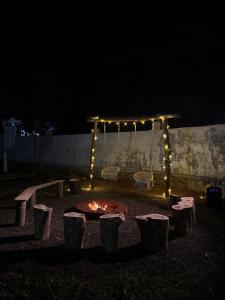 eine Feuerstelle in einem Hof in der Nacht mit Lichtern in der Unterkunft Soulstay Resort in Chinchavli