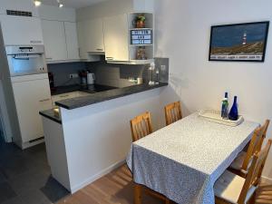 a kitchen with a table and a kitchen with white cabinets at Residence Rodin in Nieuwpoort +17 photos