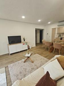 a living room with a couch and a tv at Refugio do Surf Cortegaça in Cortegaça