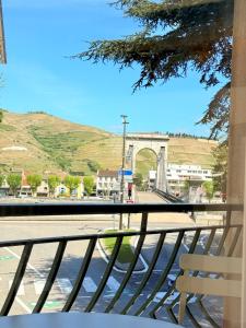 un banc sur un balcon avec vue sur un pont dans l'établissement Studio with balcony, à Tournon-sur-Rhône