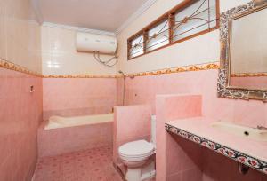 a pink bathroom with a toilet and a sink at Darsa House Ubud in Ubud