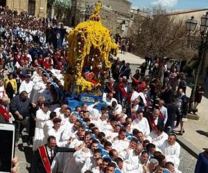 een menigte mensen voor een praalwagen in een parade bij Glory House in Mazzarino