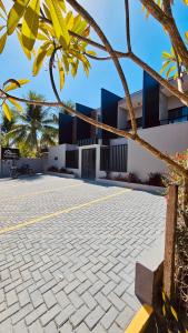 a building with a courtyard with a palm tree at Mahalo Exclusive Boutique in Maragogi