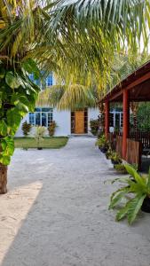 ein Haus mit einem großen Hof mit einem Gebäude in der Unterkunft Dhonveli Inn in Dhaalu Atoll