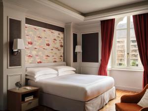 een slaapkamer met een groot wit bed en een raam bij Palazzo Venezia in Como