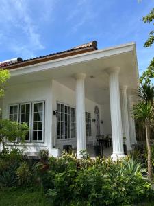 a white house with white columns at Damar Tree Resort in Krui