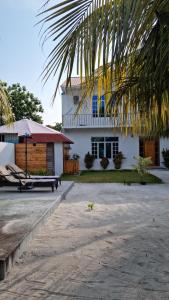 ein Haus mit einem Picknicktisch und einem Gebäude in der Unterkunft Dhonveli Inn in Dhaalu Atoll