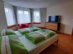 a bedroom with two beds and a tv on a dresser at Apartment Angenweg 2 by Interhome in Entlebuch