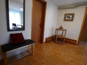a room with a mirror and a bench and a table at Apartment Angenweg 2 by Interhome in Entlebuch