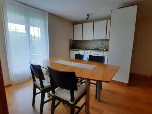 a dining room table with chairs and a kitchen at Apartment Angenweg 2 by Interhome in Entlebuch
