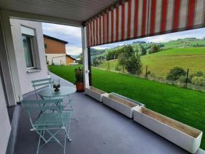 a patio with a table and chairs and a large window at Apartment Angenweg 2 by Interhome in Entlebuch