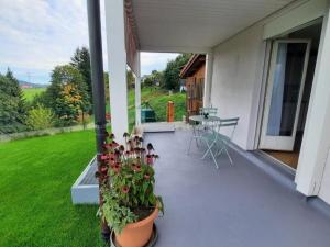 a patio with flowers and a table on a house at Apartment Angenweg 2 by Interhome in Entlebuch
