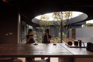 two women sitting at a table in a room at 제주 감성숙소 스테이보스케 in Jeju