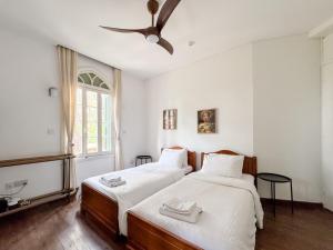 een slaapkamer met twee bedden en een plafondventilator bij Semiramis Boutique Hotel & Spa in Kato Platres