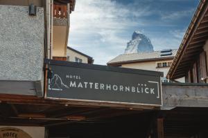 a sign with a mountain in the background at Hotel Matterhornblick in Zermatt