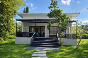 een huis met een trap naar de voortuin bij Today Sunset ที่พักวังน้ำเขียว in Ban Nong Chaeng