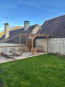 a patio with two benches and a stone building at Résidence ARTHUS Cinopé in Pierrefonds