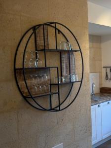 a metal shelf on a wall with glasses on it at Résidence ARTHUS Cinopé in Pierrefonds