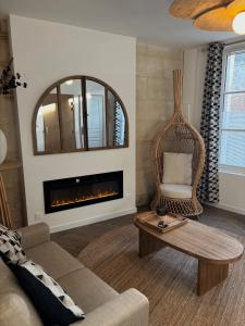 a living room with a couch and a fireplace at Résidence ARTHUS Cinopé in Pierrefonds