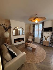 een woonkamer met een bank en een open haard bij Résidence ARTHUS Cinopé in Pierrefonds