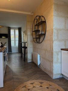 a kitchen with a stone wall with a shelf on the wall at Résidence ARTHUS Cinopé in Pierrefonds