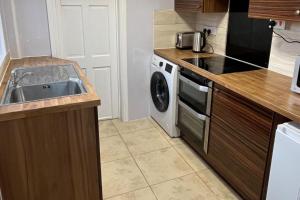 a kitchen with a sink and a washing machine at 2 Bed Flat - Sleeps 3 - Parking - Wifi in West Boldon +5 photos