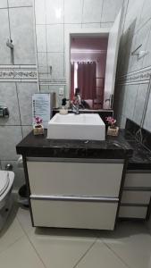 een badkamer met een witte wastafel en een spiegel bij Suíte Master, Ar condicionado,Tela Cinema 150" Netflix, Globo Pousada Tijucas Lua Encantada in Tijucas
