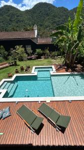 una piscina con due sedie su una terrazza di Pousada Preamare a Ubatuba