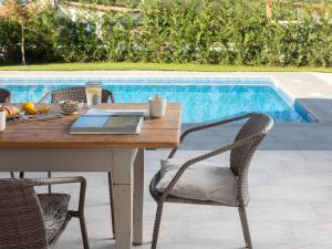 a table and chairs next to a swimming pool at Holiday Home mit eigenem Pool by Interhome in Čepljani