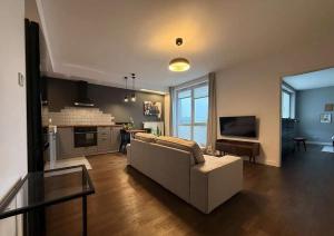 un salon avec un canapé blanc et une télévision dans l'établissement Studio in Centro Stile Buenos Aires con Check-in Automatico H24 e Parcheggio Gratuito, à Casale Monferrato