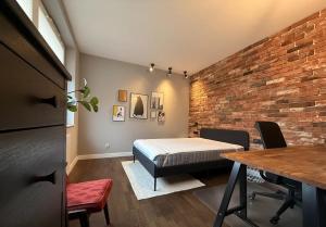 une chambre avec un lit et un mur de briques dans l'établissement Studio in Centro Stile Buenos Aires con Check-in Automatico H24 e Parcheggio Gratuito, à Casale Monferrato