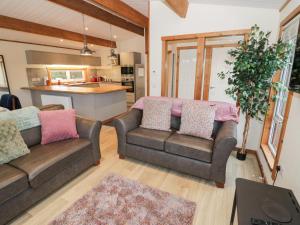 a living room with two couches and a kitchen at Elm Lodge in Rugeley +6 photos