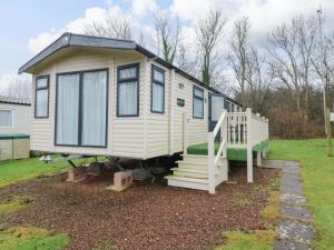 a tiny house with a staircase in a yard at Caravan number 77 in Eyemouth
