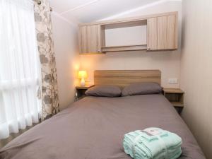 a small bedroom with a bed and a window at Caravan number 77 in Eyemouth