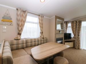 a living room with a couch and a table at Caravan number 77 in Eyemouth
