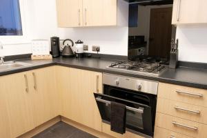 une cuisine avec une cuisinière et un évier dans l'établissement K Suites - Fulbridge Road 116, à Paston