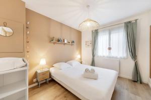 een slaapkamer met een groot wit bed en een raam bij Suzanne House 2 Bedrooms Private garden in Saint-Coulomb