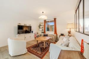 een woonkamer met een witte bank en een tafel bij Suzanne House 2 Bedrooms Private garden in Saint-Coulomb