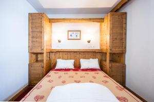 una camera da letto con un letto in una stanza di Duplex confortable avec piscine a La Toussuire Altre 20 foto