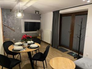 a room with a table and chairs and a living room at Apartament Górska Przystań Kluszkowce in Kluszkowce