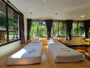 two beds in a room with large windows at Puprai Tarnnarm Resort in Thong Pha Phum +61 photos